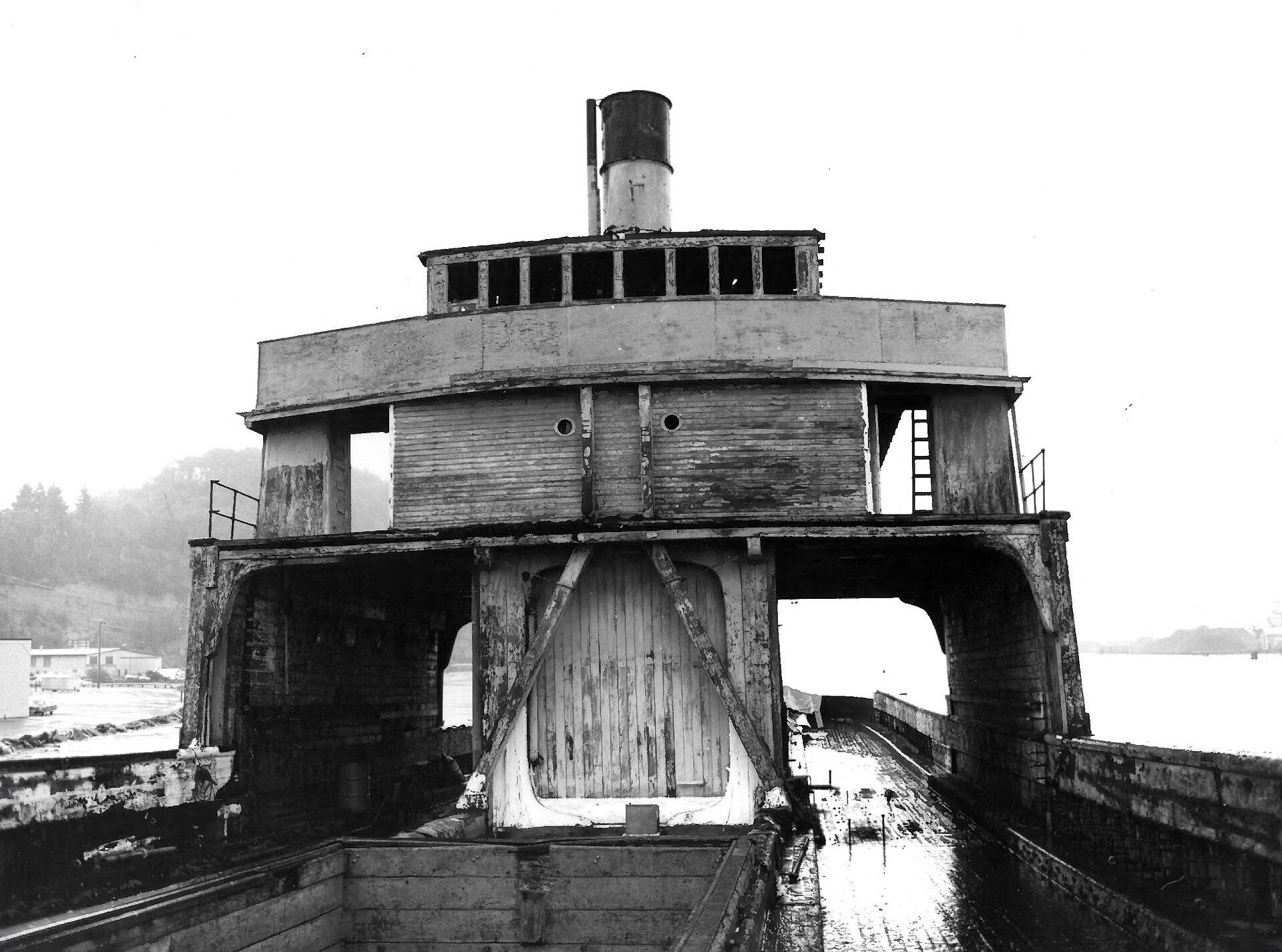 A dilapidated steamboat structure with a visible chimney, likely from the early to mid-20th century.